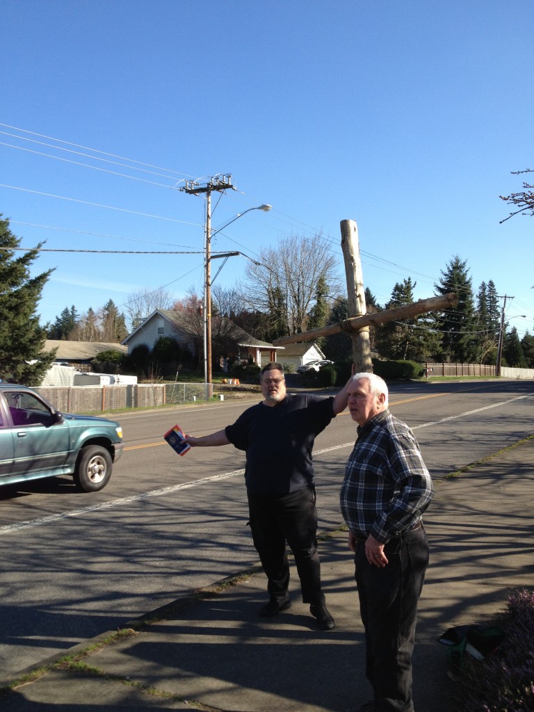 Steve and Dennis standing on the sidewalk along Hall Blvd. with the cross and  Bibles and tracts.