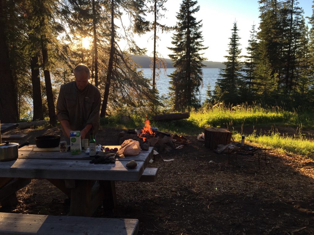 Natan cooking dinner over the campfire.
