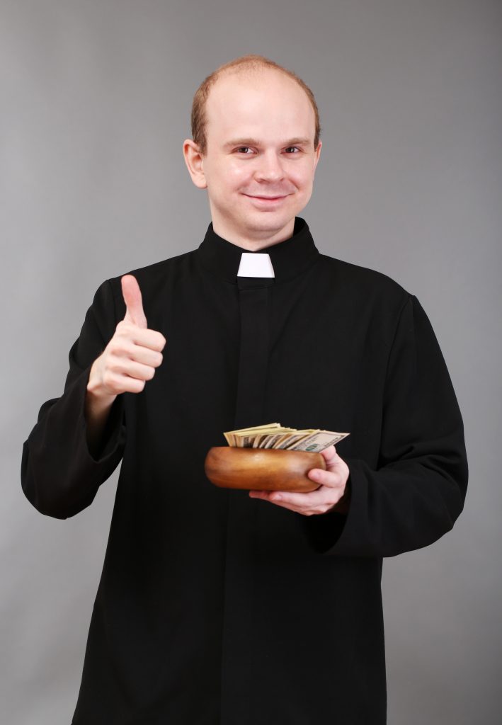 Young pastor with money on gray background